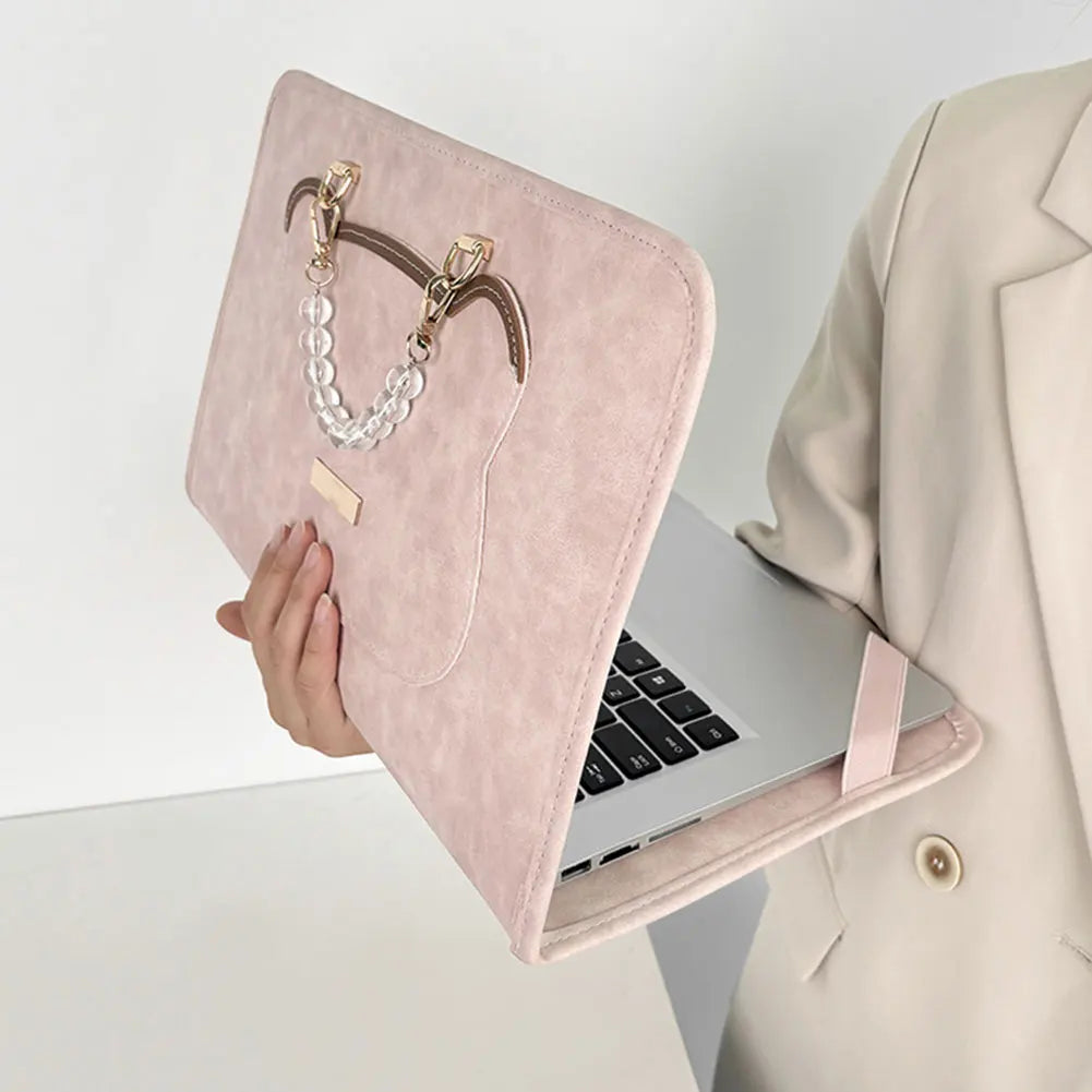 A pink water-resistant laptop briefcase with a leather strap and pearl necklace is shown next to an open laptop.