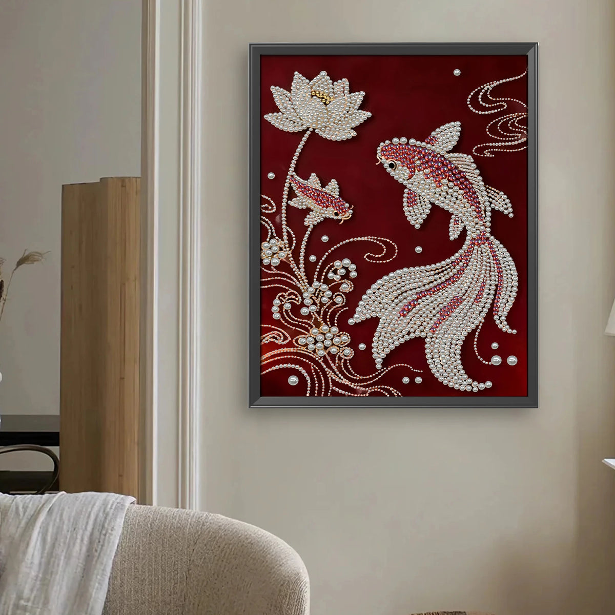 A framed painting featuring a white pearl design on a deep red background, suitable for wall decor.