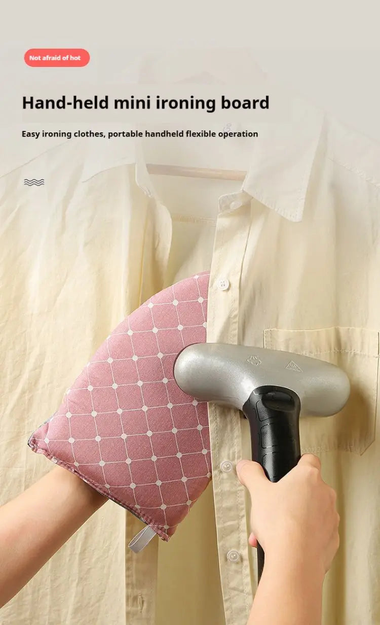 A hand is using a handheld mini ironing board to iron a shirt, demonstrating flexible portable ironing.