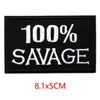 Black embroidered iron-on letter patch with white text 100% SAVAGE and dimensions 8.1x5cm