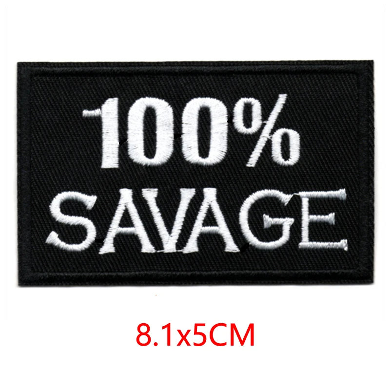 Black embroidered iron-on letter patch with white text 100% SAVAGE and dimensions 8.1x5cm