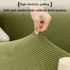 A hand gently pulls on a textured olive green sofa cover to demonstrate its high elasticity and comfort without deformation.