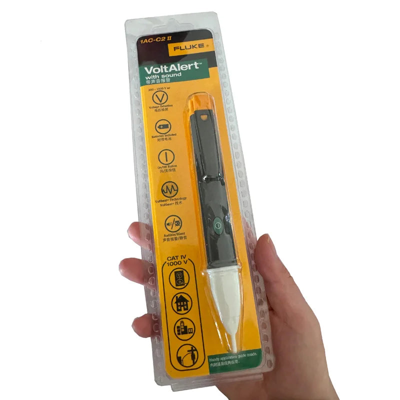A hand holds a Fluke VoltAlert non-contact voltage tester pen with yellow and black casing.