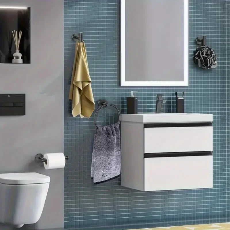 A bathroom setup featuring a mirror, sink cabinet, and various stainless steel accessories like towel rings and hooks on a ti