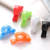 A set of colorful key holder clips in red, green, white, and black are displayed on a white surface.