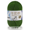 A ball of bright green milk cotton blend yarn labeled in Chinese and English with a small illustration of a cow.