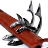 A close-up of a shark-design guitar capo with a zinc alloy build mounted on a wooden neck.