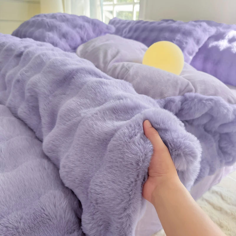 A hand is touching a fluffy purple fleece duvet cover with a rabbit design.