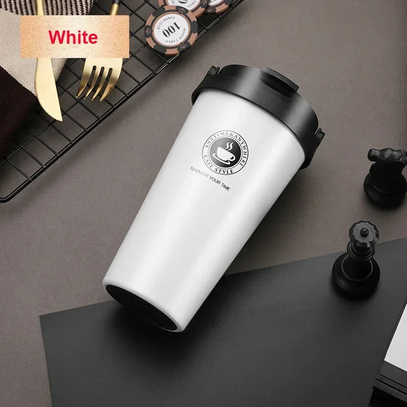 Weiße, isolierte Reise-Kaffeetasse auf dunkler Oberfläche neben Gabel und Messer.