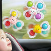 A child is shown in a car seat looking at a set of colorful, flower-shaped bath toys designed for easy access.