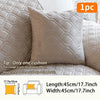 A single cream colored cushion with a quilted geometric pattern shown on a sofa.