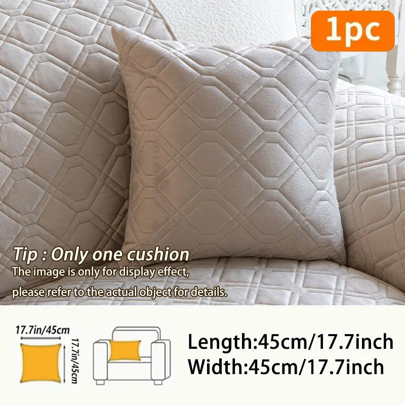 A single cream colored cushion with a quilted geometric pattern shown on a sofa.