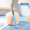 A blue ergonomic crochet hook with a bee design is shown next to a ball of light pink yarn.