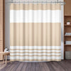 A beige and white striped waffle weave shower curtain hanging on a rod.