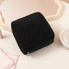 Black ribbed storage pouch with a zipper lying on a light surface.