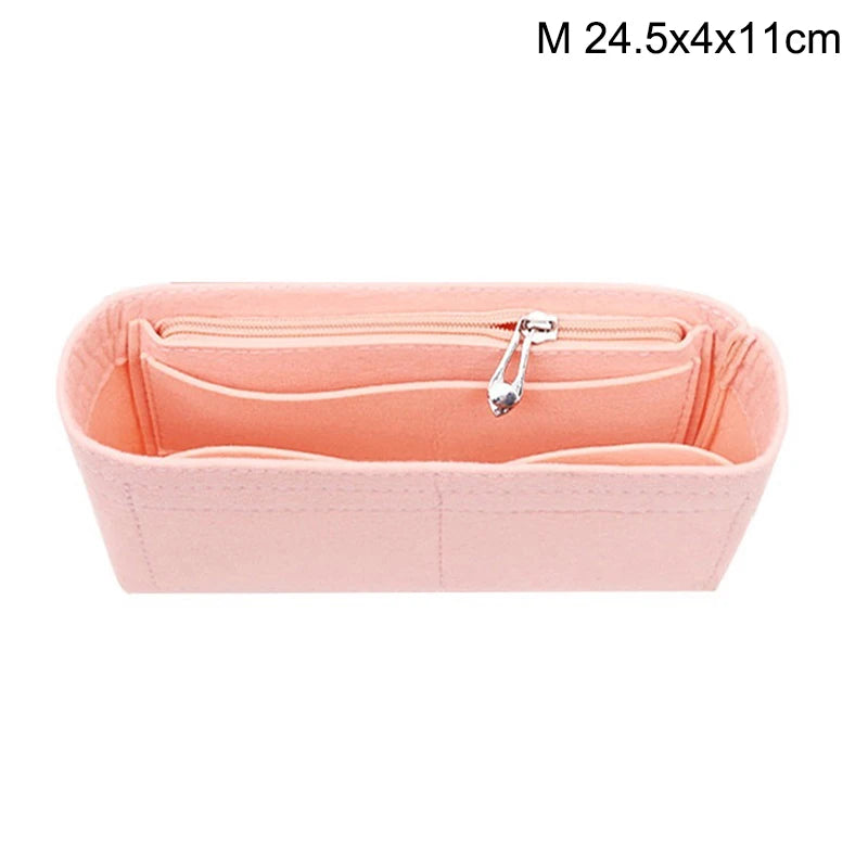 A pink felt bag organizer with multiple internal pockets and a silver zipper.