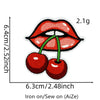 A close-up of a red cherry embroidered patch showing the size and texture.