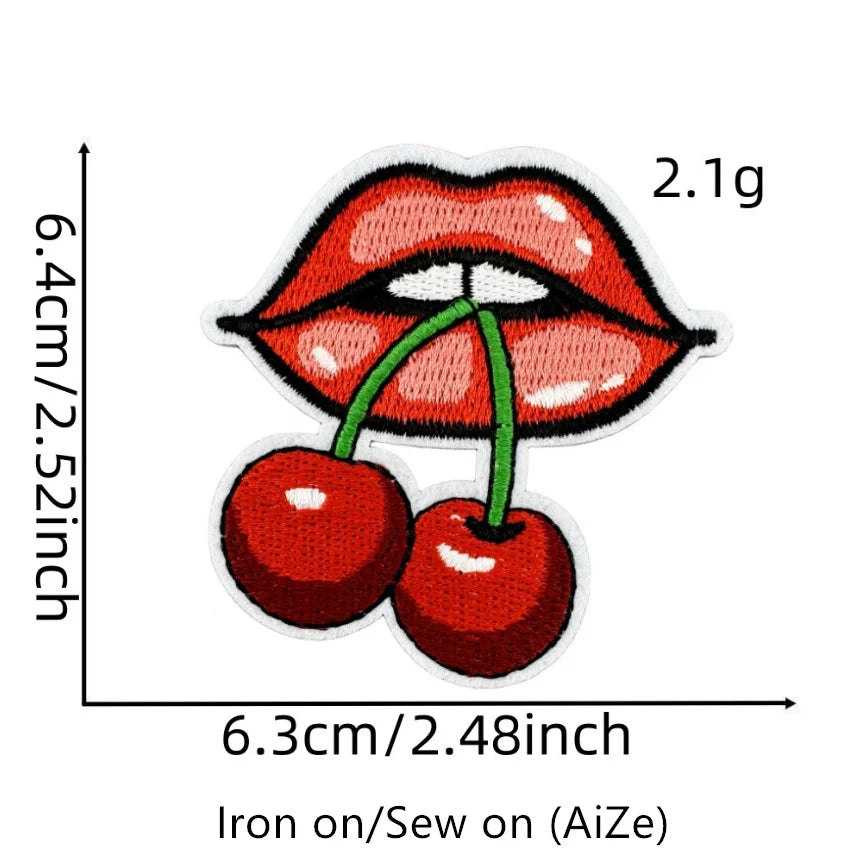 A close-up of a red cherry embroidered patch showing the size and texture.