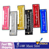 A collection of ten harmonica keys in various colors including pink, yellow, black, red, and blue.