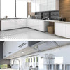 A close-up of a kitchen countertop with stainless steel utensils and a marble surface.