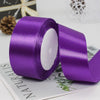 A roll of vibrant purple satin ribbon used for gift wrapping and DIY crafts.