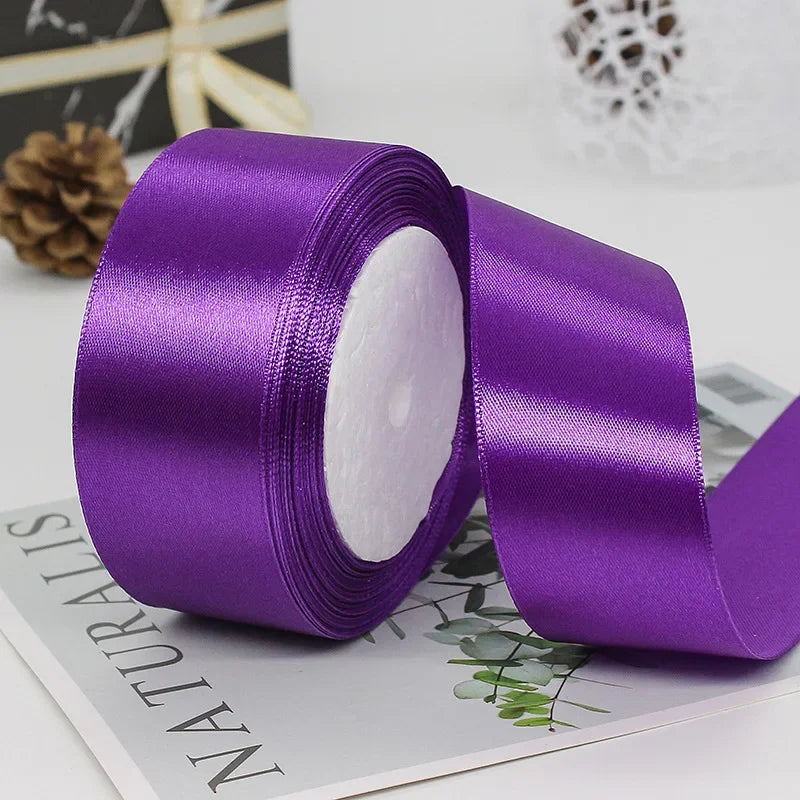 A roll of vibrant purple satin ribbon used for gift wrapping and DIY crafts.
