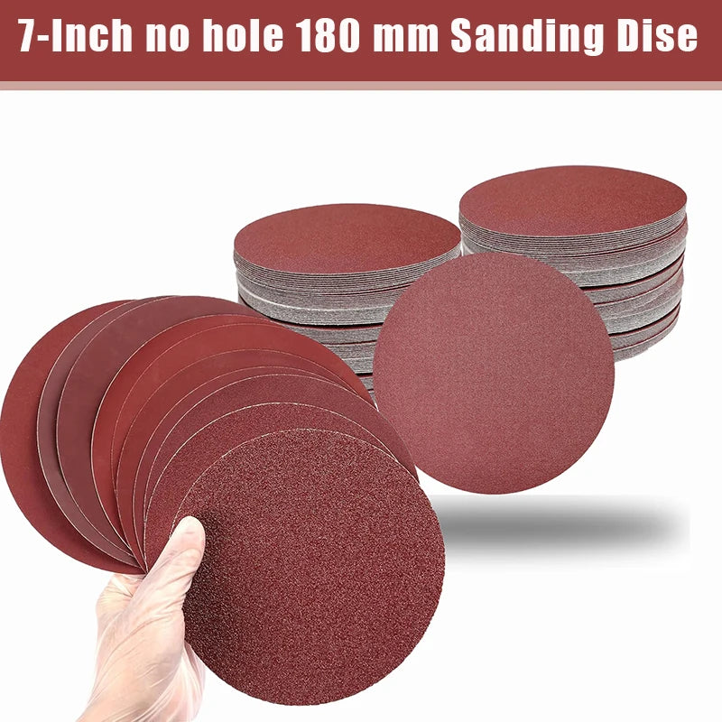 A hand holds a reddish-brown sanding disc, with several stacked discs visible in the background.
