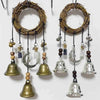 A set of witch bells door hangers and wind chimes made of natural wood and glass hanging from a rack.
