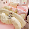 A bed with a solid cotton bedding set featuring light yellow and pink duvet covers and pillows.