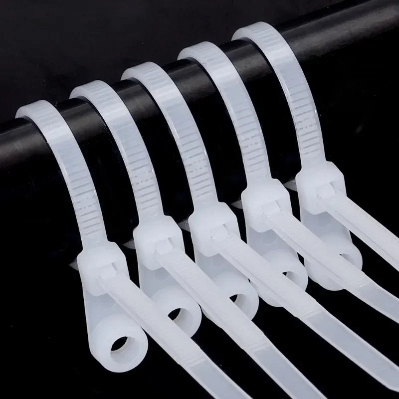 A row of clear, reusable screw-hole cable ties with mounting holes arranged horizontally.