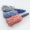Three cleaning brushes of varying colors including black gray blue and red with ergonomic handles