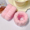 Pink microfiber wrist sweatband and scrunchies for face washing displayed on a white surface.
