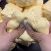 Hände drücken einen gelben, weichen Stressball-Fidget-Spielzeug.