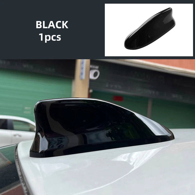 Black shark fin antenna cover for a white car roof.