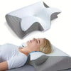 Un cojín cervical de espuma viscoelástica blanco junto a una persona durmiendo en una almohada.