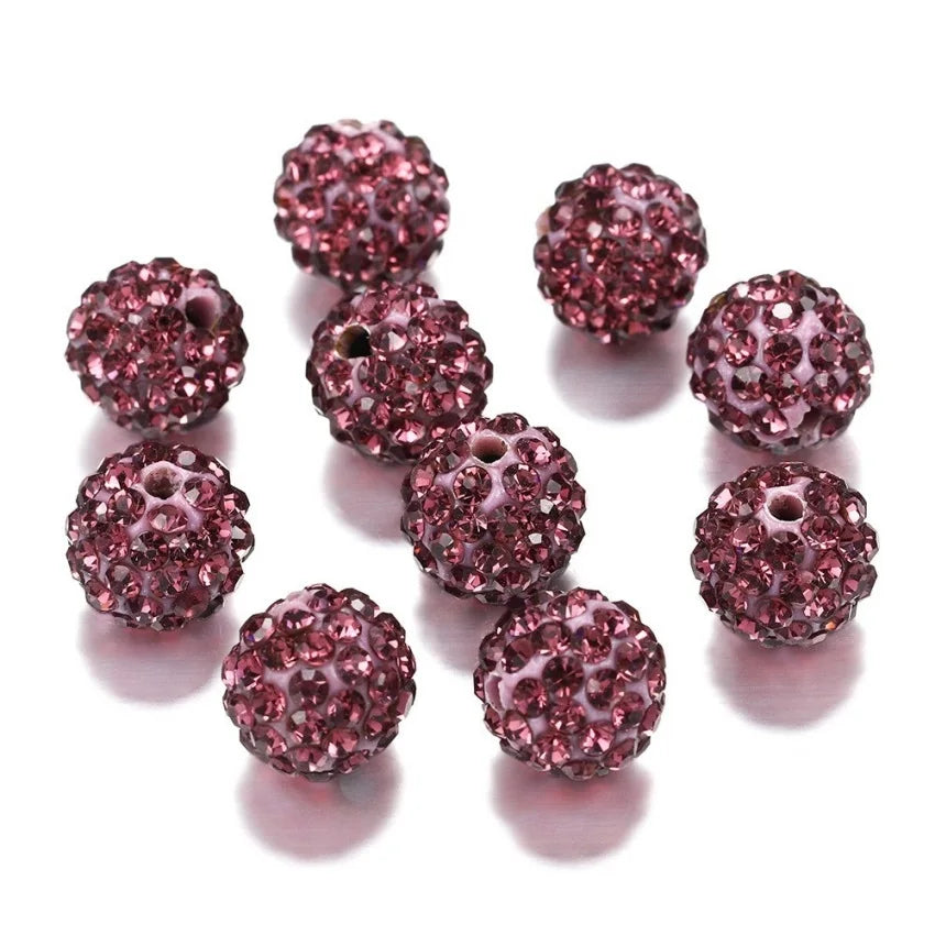 A collection of round, deep pink crystal clay beads for DIY jewelry and craft projects.