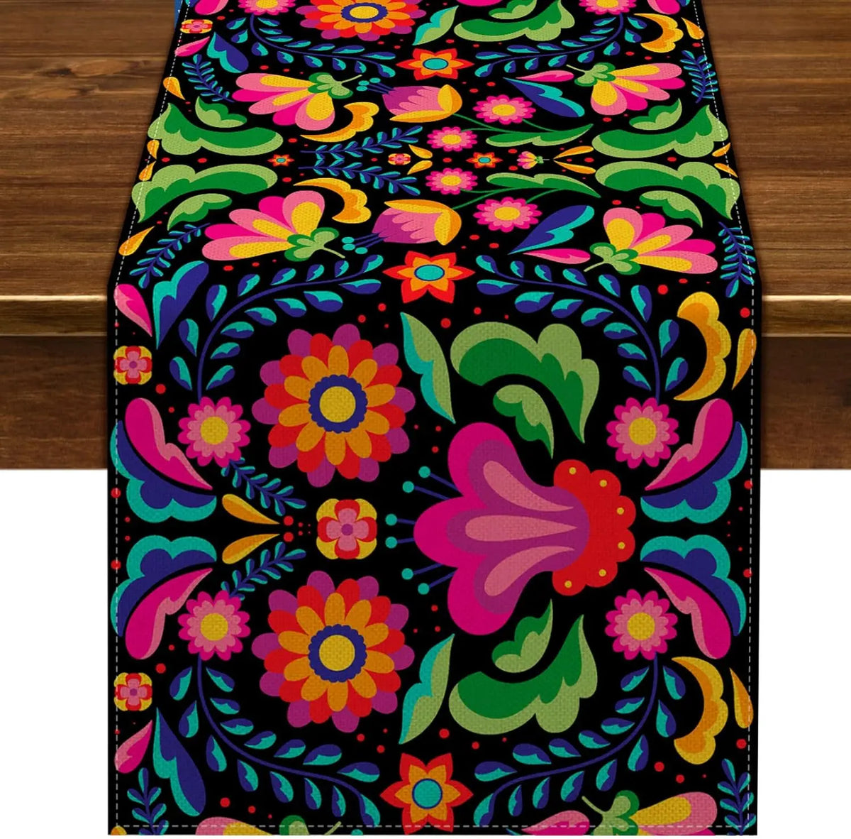A vibrant floral pattern table runner featuring bright pink, purple, orange, and green flowers on a black background.