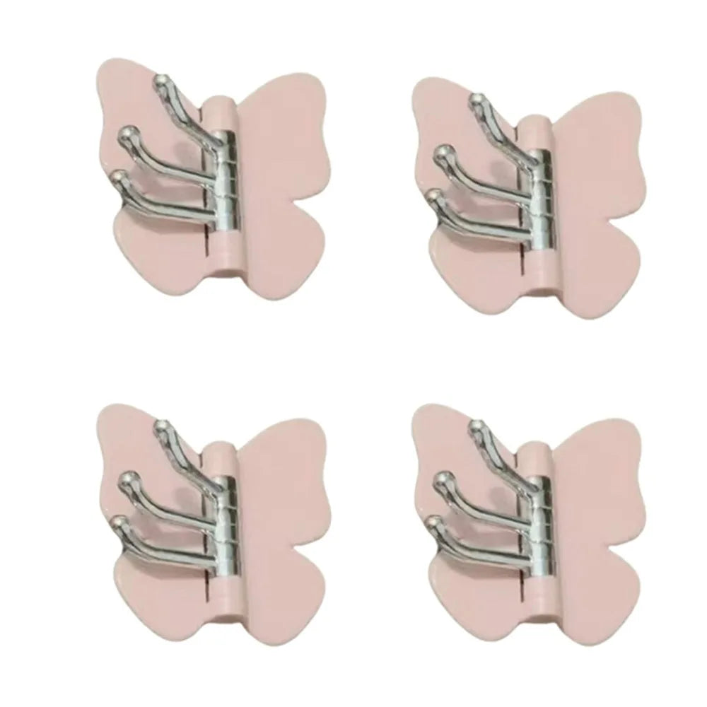 Un juego de ganchos decorativos de mariposa giratoria rosa con brazos plateados.