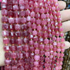 A close-up of pink and reddish rose quartz square faceted beads strung together for jewelry making