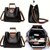 A black leather vintage crossbody tote bag with brown trim and multiple interior pockets.