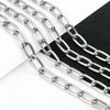 Silver stainless steel chain links laid out on a dark surface.