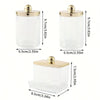 Clear glass apothecary jar with a golden lid, used for cotton balls and swabs.