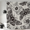 Gothic skull shower curtain featuring a black and white design of moths and floral patterns.