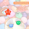 A hand holds a bright orange star-shaped ball next to various colorful, delicate spherical balls used for baby care.