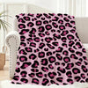 A pink leopard print flannel throw blanket draped over a light-colored sofa.