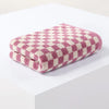 A stack of pink and cream plaid cotton bath towels