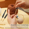 A hand is using a smooth aluminum crochet hook to work on yarn, demonstrating the ease of use for intricate stitching.