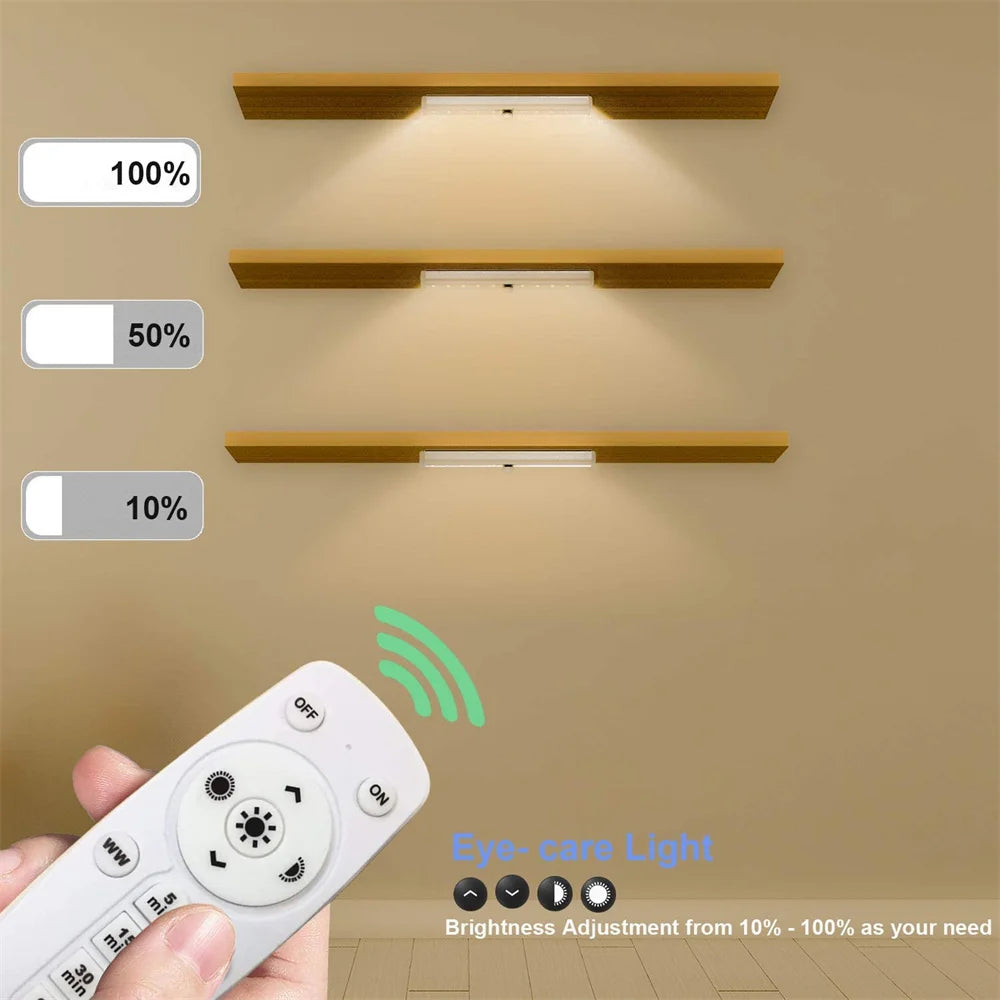 A rechargeable LED under-cabinet light fixture with three brightness levels and a remote control mounted on a beige wall.