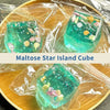 A translucent teal cube shaped like a star island, packaged for stress relief.