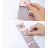 A hand holds a pink PU leather jewelry organizer pouch with four compartments, showing its internal structure.